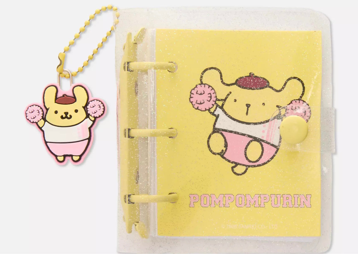 Yellow notebook with Pompompurin character design and charm on a white background
